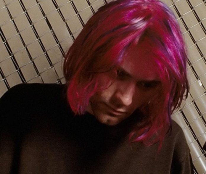 Kurt Cobain dying his hair purplish red. 